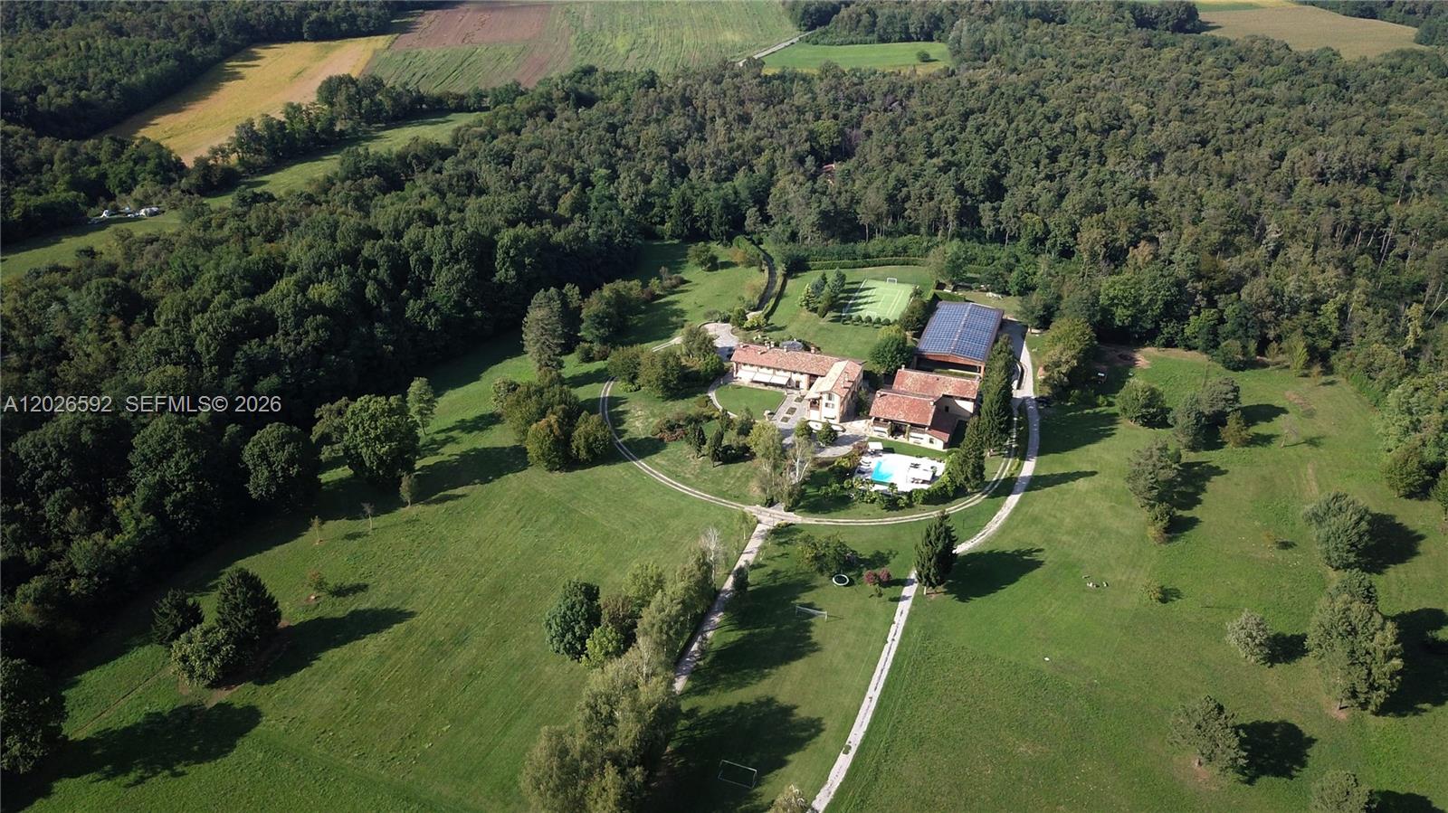 An aerial view shows a large estate with a house, pool, and tennis court — Lombardia Venegono Superiore, VA 20100, VA