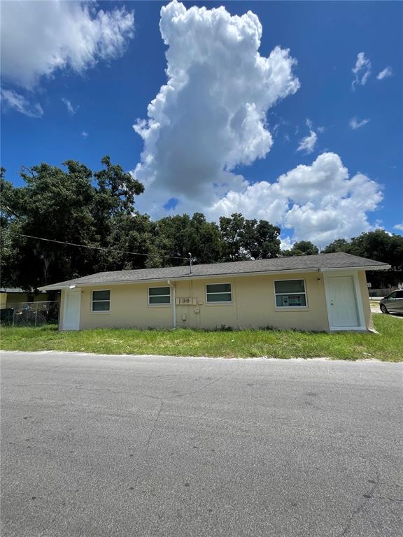A single-story, light yellow exterior building with two white doors and three windows — 403 TERRY STREET, WILDWOOD, FL