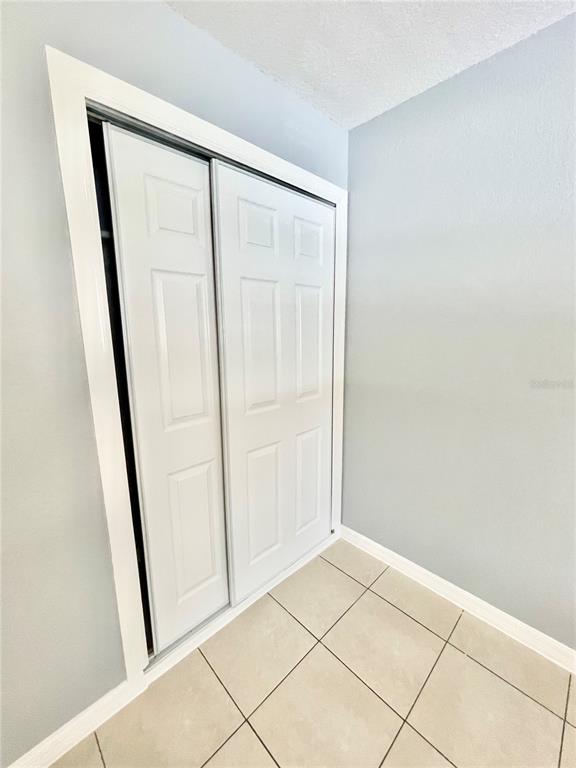 A white sliding closet door is set against a light blue wall with tiled flooring — 403 TERRY STREET, WILDWOOD, FL