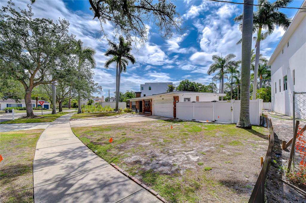 A single-story house with a white garage and fence sits on a grassy corner lot — 5006 W DICKENS AVENUE, TAMPA, FL