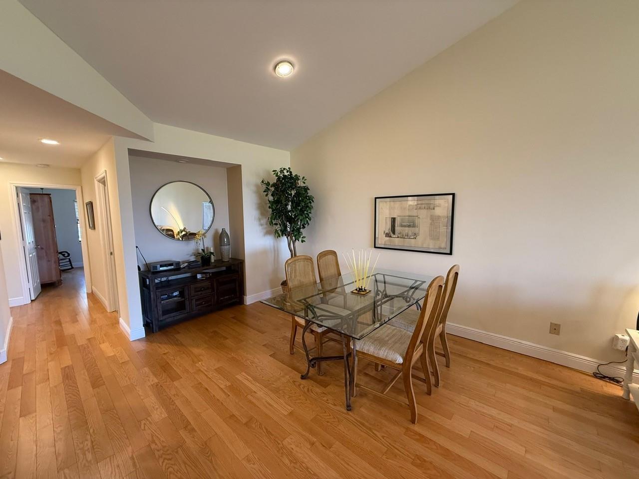 A dining room with a glass-topped table, wooden chairs, and a dark wood sideboard — 6102 SE Landing Way # 13, Stuart FL 34997, STUART, FL