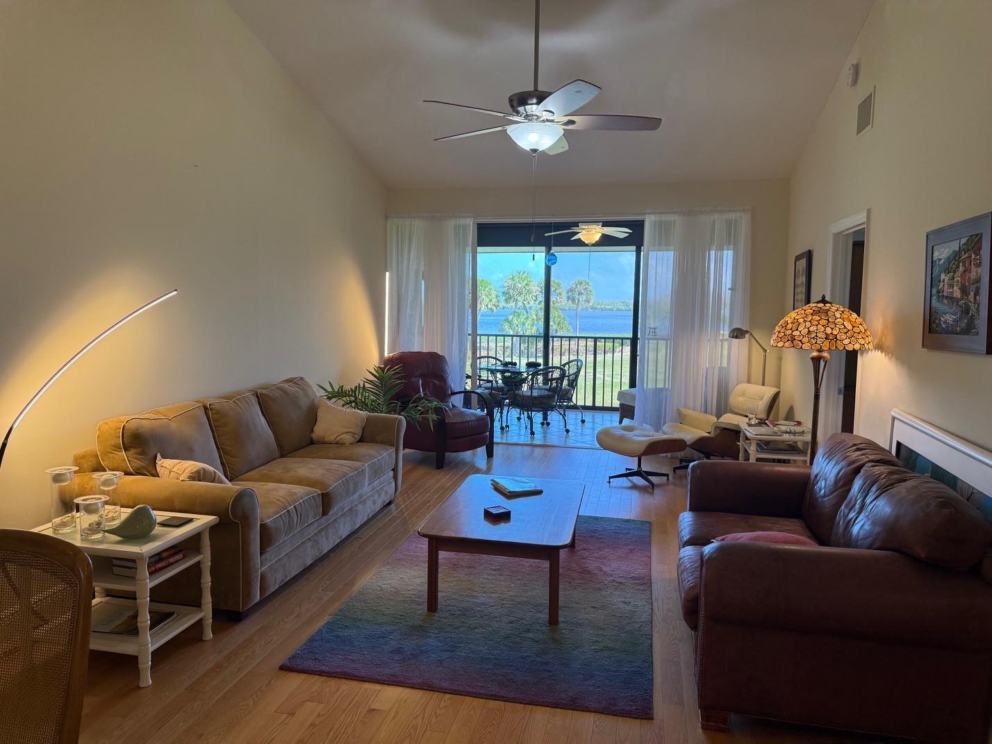 A living room with two sofas, a coffee table, and a balcony overlooking a lake — 6102 SE Landing Way # 13, Stuart FL 34997, STUART, FL