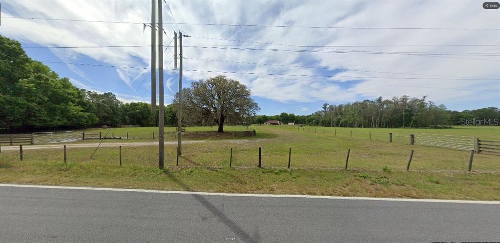 A large, open grassy field with a prominent oak tree and perimeter fencing — GREEN POND RD, POLK CITY, FL