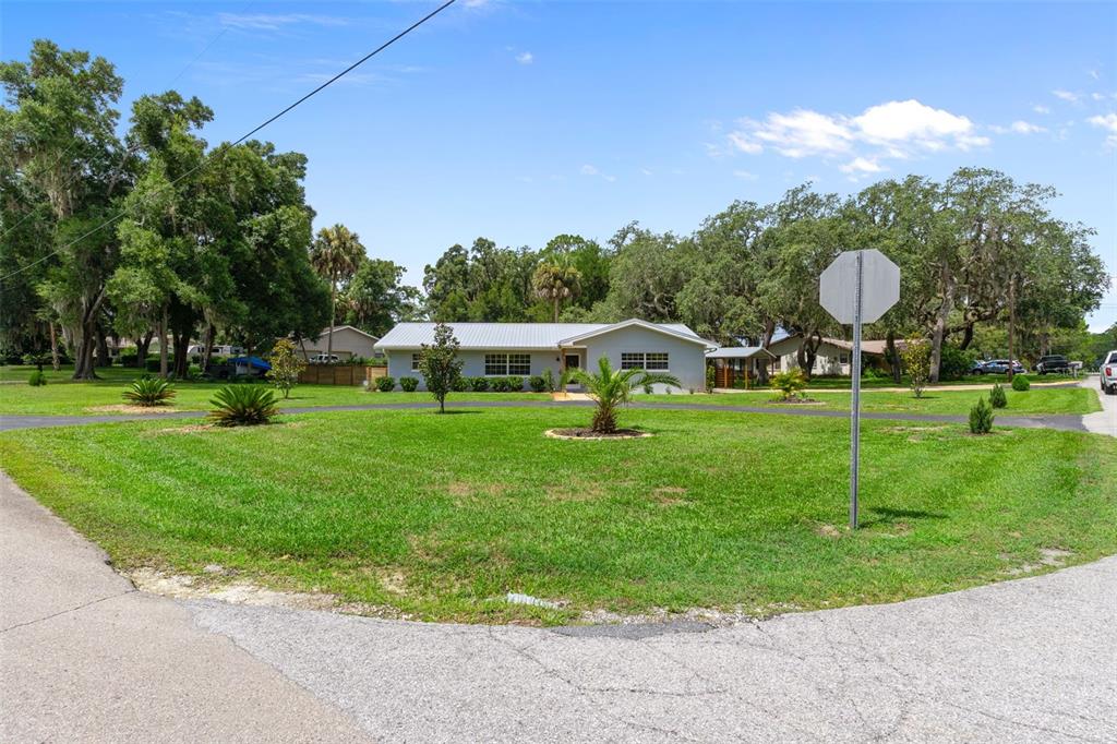 A single-story house with a light-colored exterior sits behind a large, grassy front yard — 914 N MCGOWAN AVENUE, CRYSTAL RIVER, FL