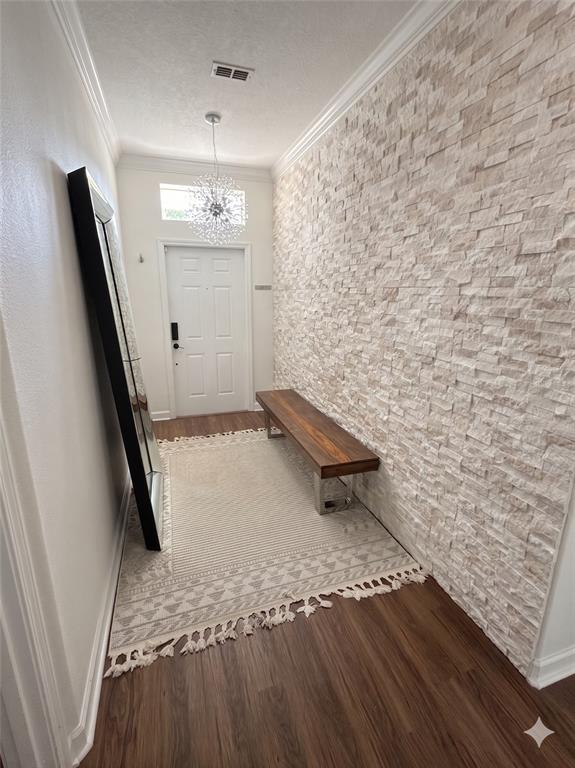 An entryway features a stone accent wall, a wooden bench, a rug, and a floor mirror — 2997 BUCCANEER PALM ROAD, KISSIMMEE, FL