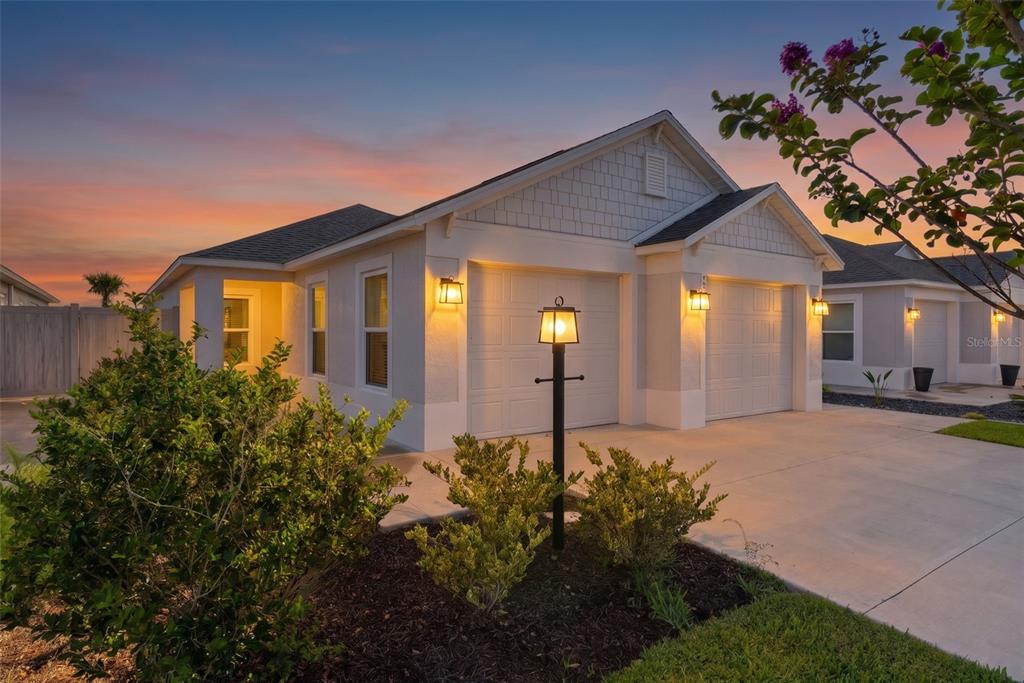 A single-story house with a two-car garage and a lamp post in the front yard — 1363 DARREN DRIVE, THE VILLAGES, FL