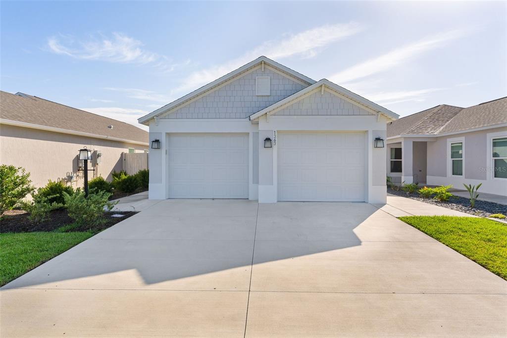 A single-story house with a two-car garage and a concrete driveway — 1363 DARREN DRIVE, THE VILLAGES, FL