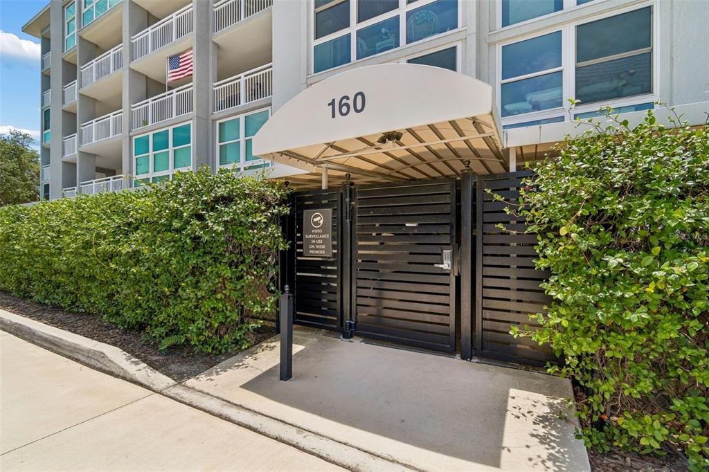 A multi-story residential building features balconies and large windows under a clear blue sky — 160 COLUMBIA DRIVE UNIT 206, TAMPA, FL