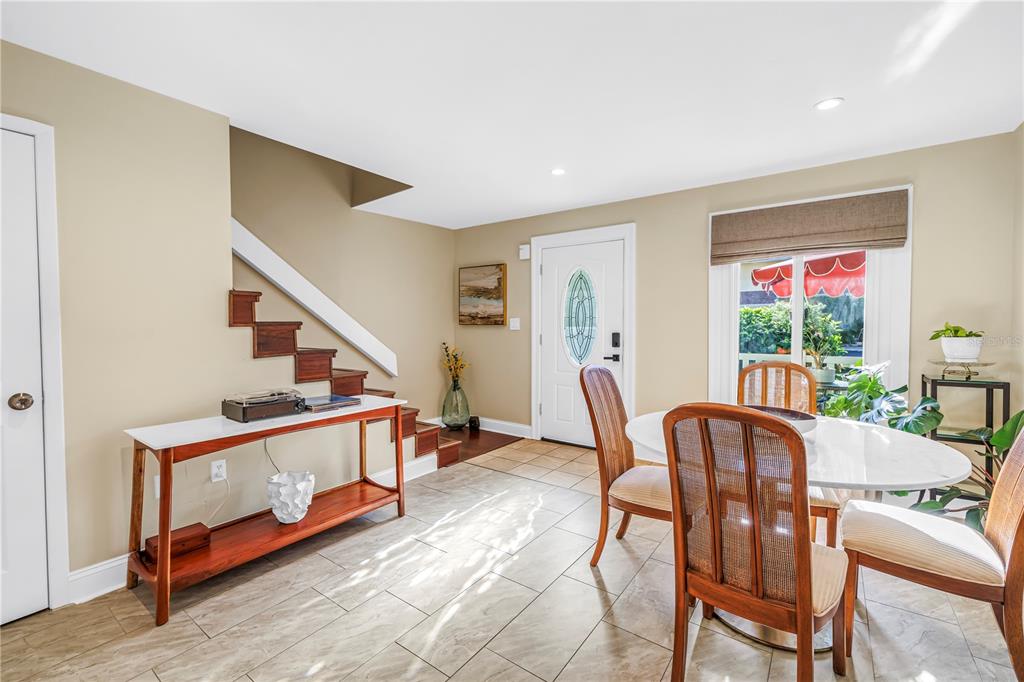 A dining area with tile floors, a staircase, and a white table with wooden chairs — 3595 41ST LANE S UNIT D, ST PETERSBURG, FL