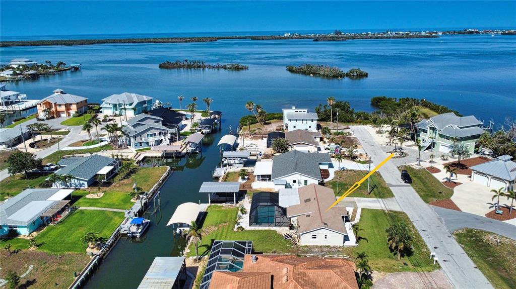An aerial view shows waterfront houses with boat docks, swimming pools, and surrounding coastal vegetation — 1933 OREGON TRAIL, ENGLEWOOD, FL