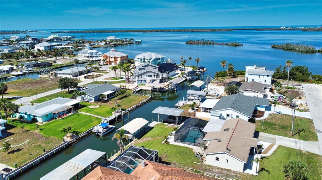 An aerial view shows waterfront houses with boat docks along a canal near the ocean — 1933 OREGON TRAIL, ENGLEWOOD, FL
