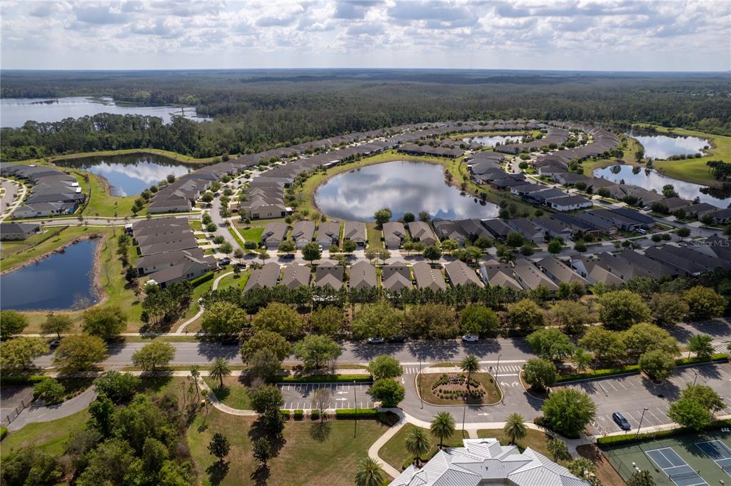 An aerial view of a residential neighborhood featuring multiple ponds and a community clubhouse — 3464 SAGEBRUSH STREET, HARMONY, FL