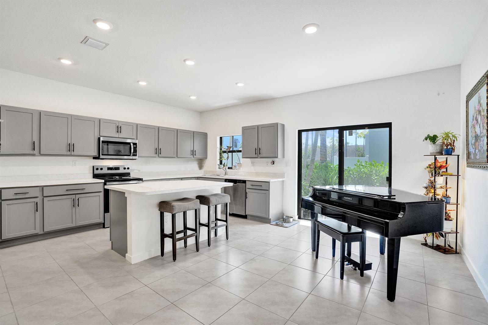 A kitchen with grey cabinets, white countertops, a center island, and a black grand piano — 975 NW 3rd Terrace, Pompano Beach FL 33060, POMPANO BEACH, FL