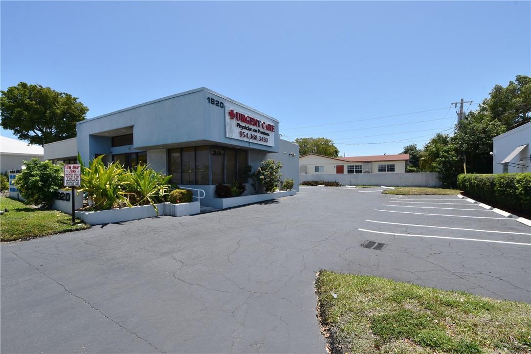 An exterior view of a single-story commercial building with a parking lot in front — 1820 E Commercial Boulevard, Fort Lauderdale FL 33308, FORT LAUDERDALE, FL