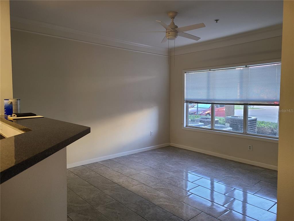 A dining area features tile flooring, a ceiling fan, and a large window with blinds — 4802 51ST STREET W UNIT 602, BRADENTON, FL