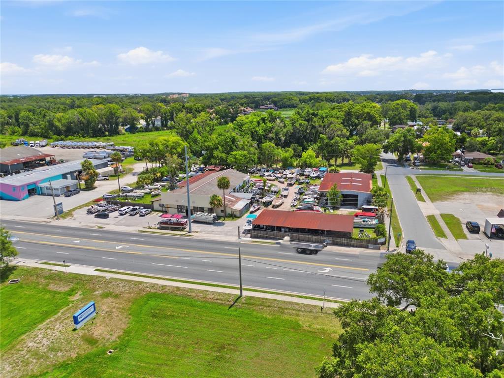 An aerial view shows a commercial property with a boat dealership along a road — 1200 S 14TH STREET, LEESBURG, FL