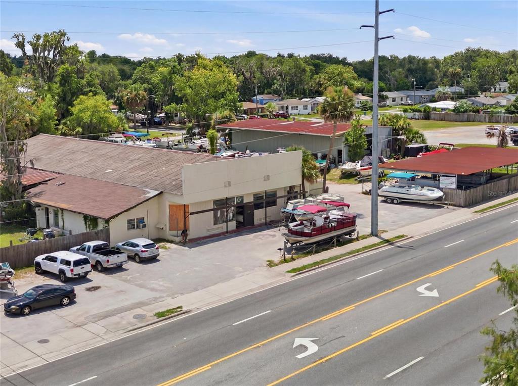 An aerial view shows a commercial property with multiple buildings and a large boat storage yard — 1200 S 14TH STREET, LEESBURG, FL