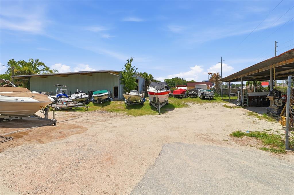 An aerial view shows a commercial property with multiple buildings and many boats stored outside — 1200 S 14TH STREET, LEESBURG, FL
