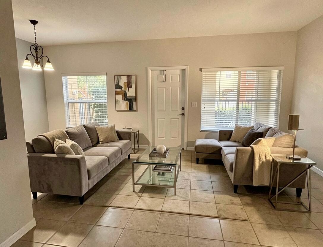 A living room features two gray sofas, a glass coffee table, and tile flooring — 161 Monterey Bay Drive, Boynton Beach FL 33426, BOYNTON BEACH, FL