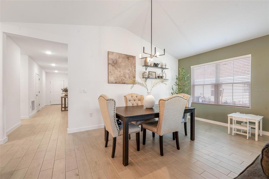 A dining room features a dark wood table, upholstered chairs, and an olive green accent wall — 17 BIRCHWOOD PLACE, PALM COAST, FL