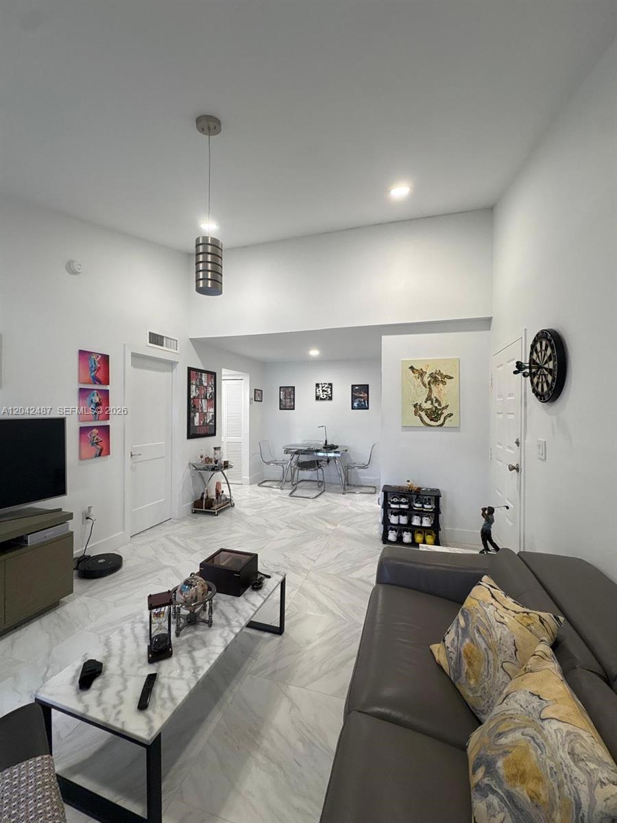 A living room with light tile floors, a grey sofa, and a dining area — 15560 SW 80th St # 205, Miami FL 33193, MIAMI, FL