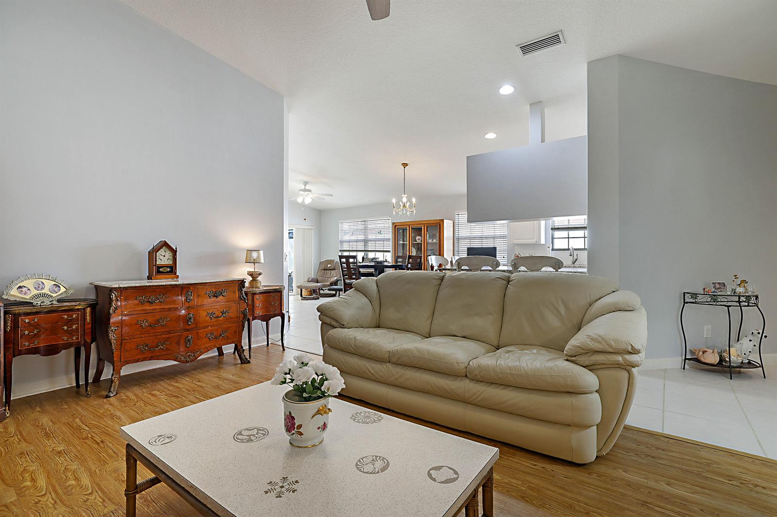 A living room features a beige leather sofa, a coffee table, and an ornate dresser — 774 SW Balmoral Trace, Stuart FL 34997, STUART, FL