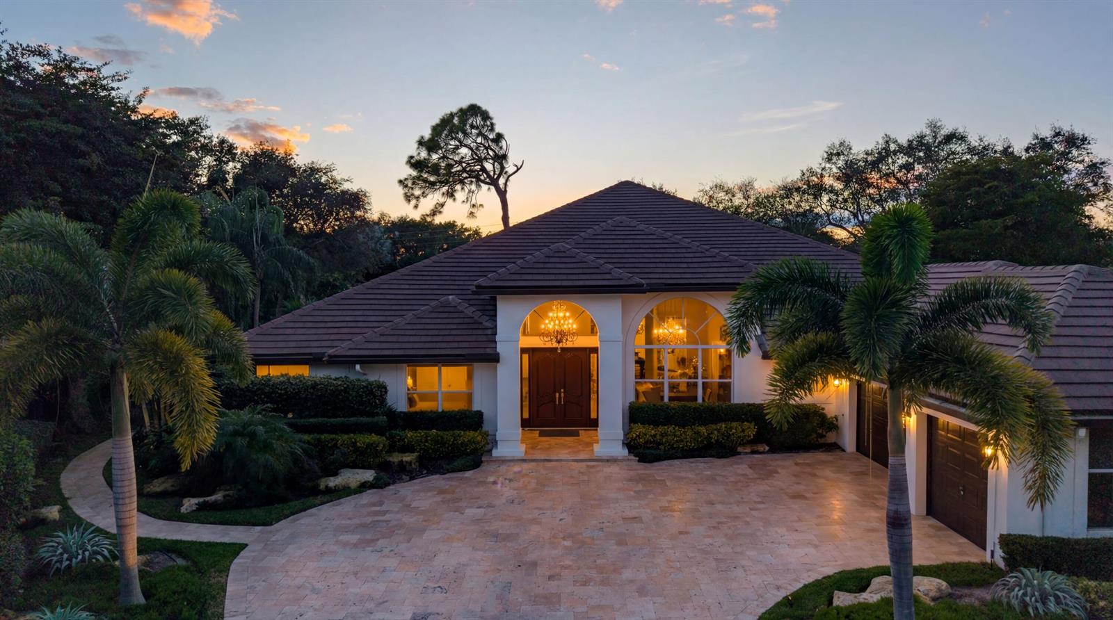 An exterior view of a single-story home with a tiled roof, arched entryway, and driveway — 4475 NW 24th Terrace, Boca Raton FL 33431, BOCA RATON, FL