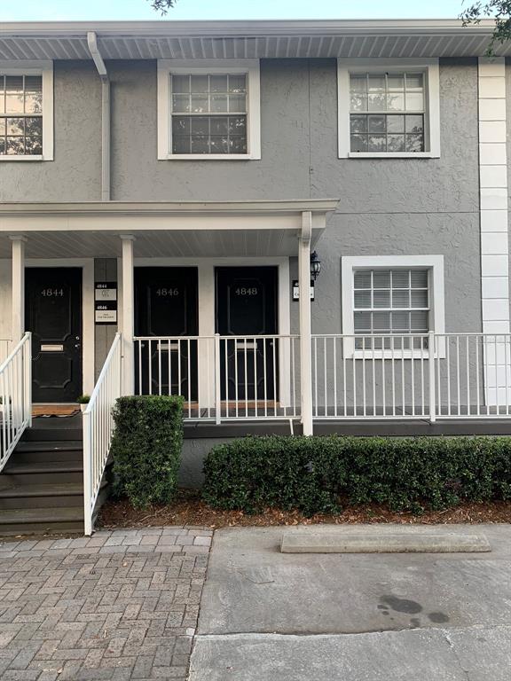 The exterior of a gray multi-unit building features three black doors and a white railing — 4828 W GANDY BOULEVARD UNIT B27, TAMPA, FL