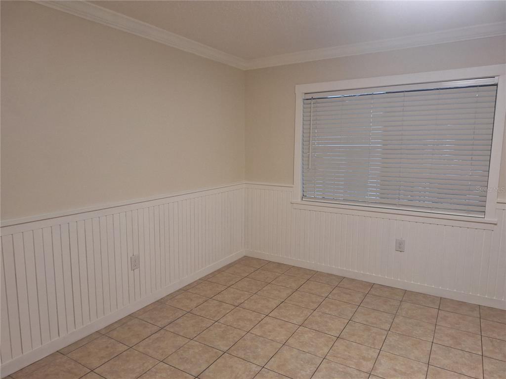 An empty room features beige walls, white wainscoting, a window with blinds, and tiled flooring — 136 BLUE POINTE WAY UNIT 350, ALTAMONTE SPRINGS, FL