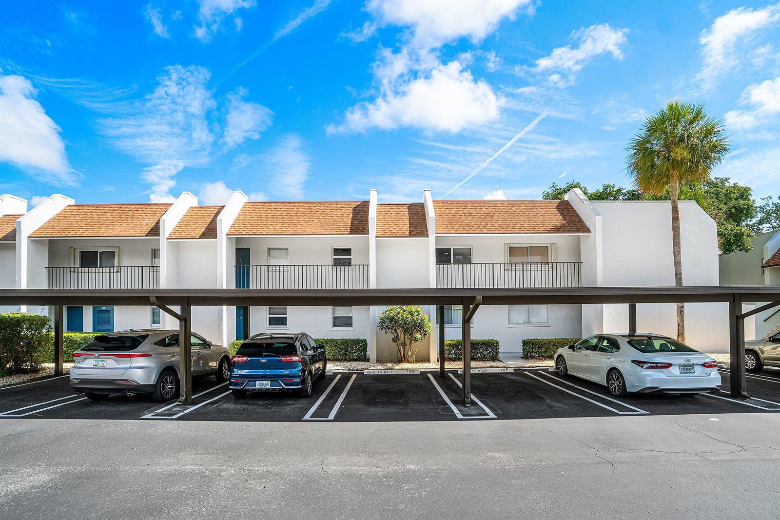 A two-story white apartment building with a brown shingled roof and a covered parking area — 2905 SW 22nd Avenue # 202, Delray Beach FL 33445, DELRAY BEACH, FL