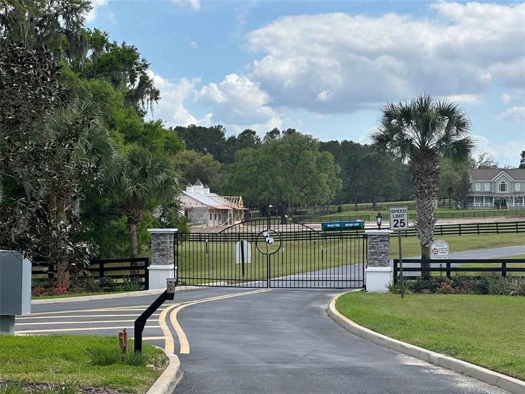 A gated entrance leads to a driveway with a speed limit sign and a construction site — 11 SW 144TH COURT, OCALA, FL