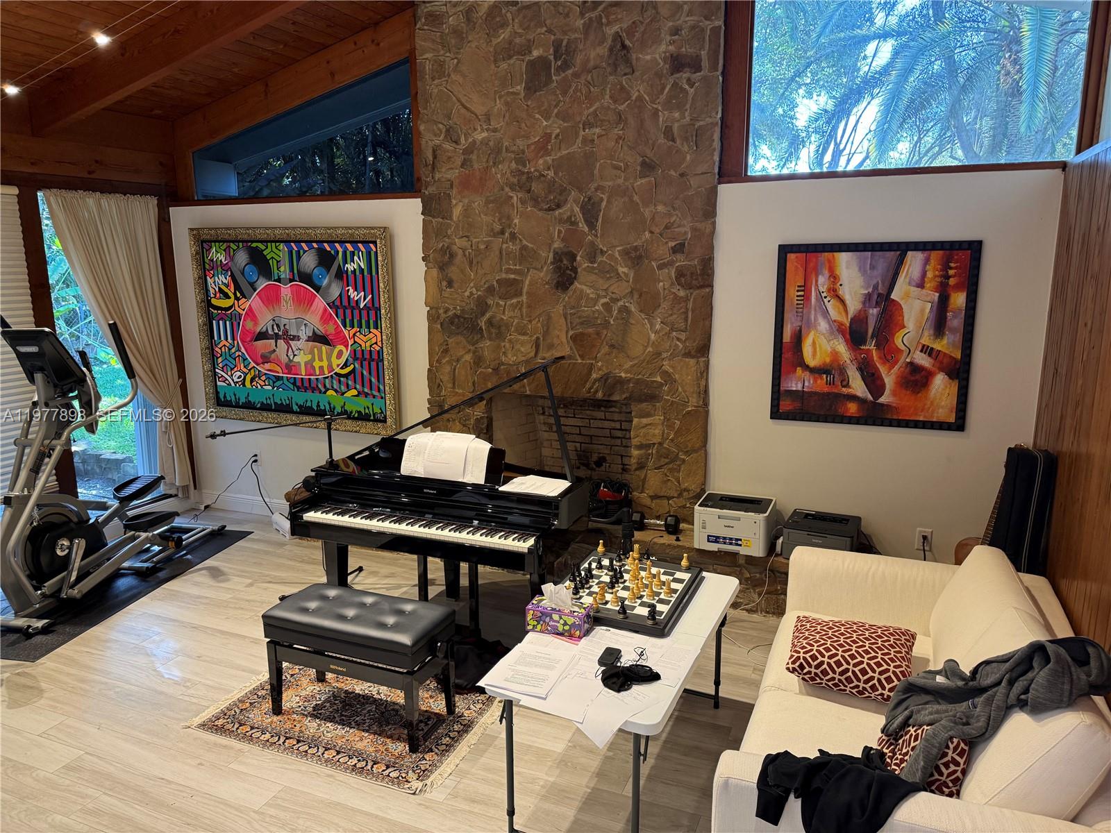 A living room features a grand piano, stone fireplace, exercise equipment, and a chess set — 6399 SW 100th St # 0, Pinecrest FL 33156, PINECREST, FL