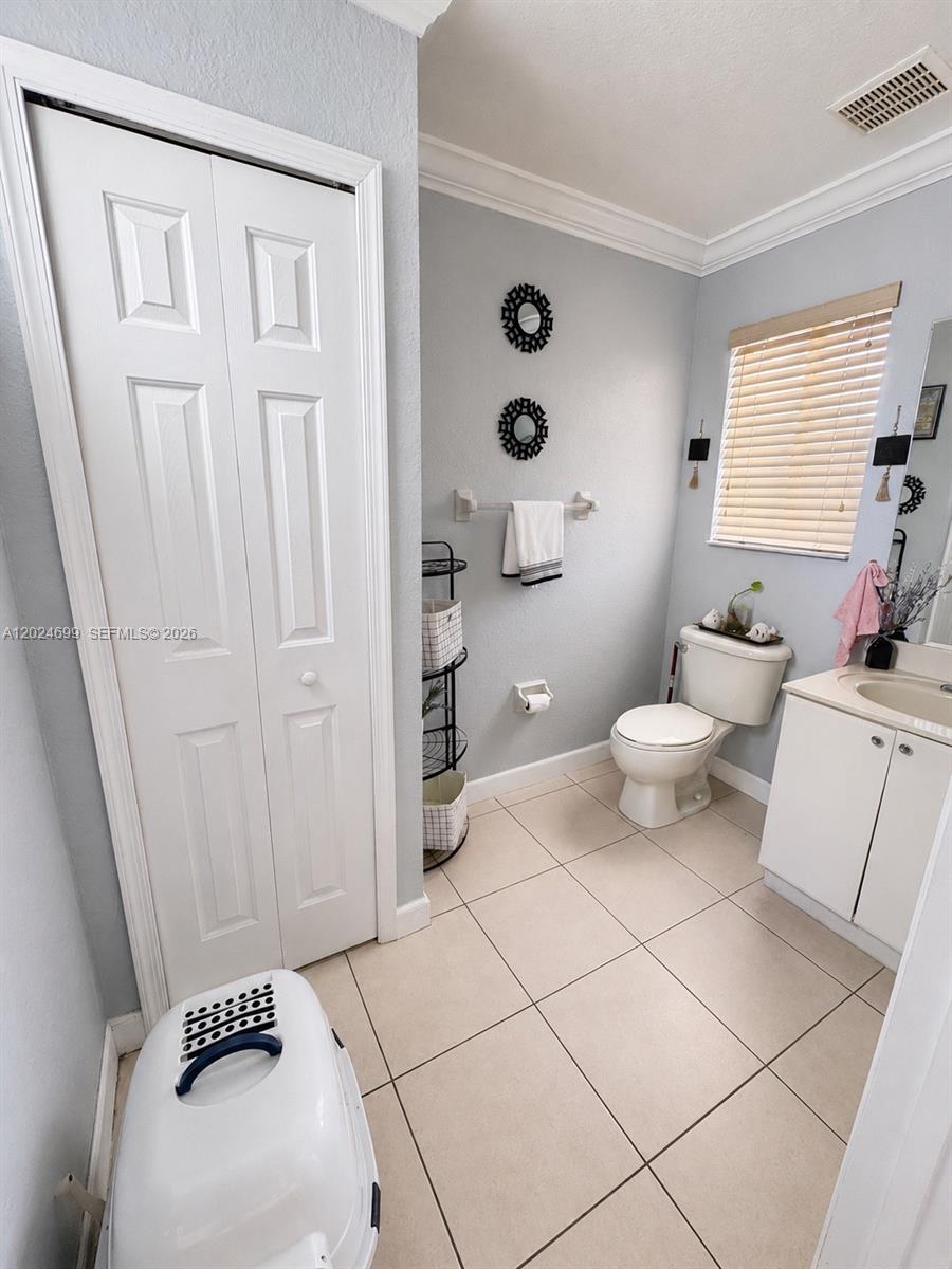 A bathroom features light gray walls, tile flooring, a white vanity, and a toilet — 7305 NW 173rd Dr # 102, Hialeah FL 33015, HIALEAH, FL