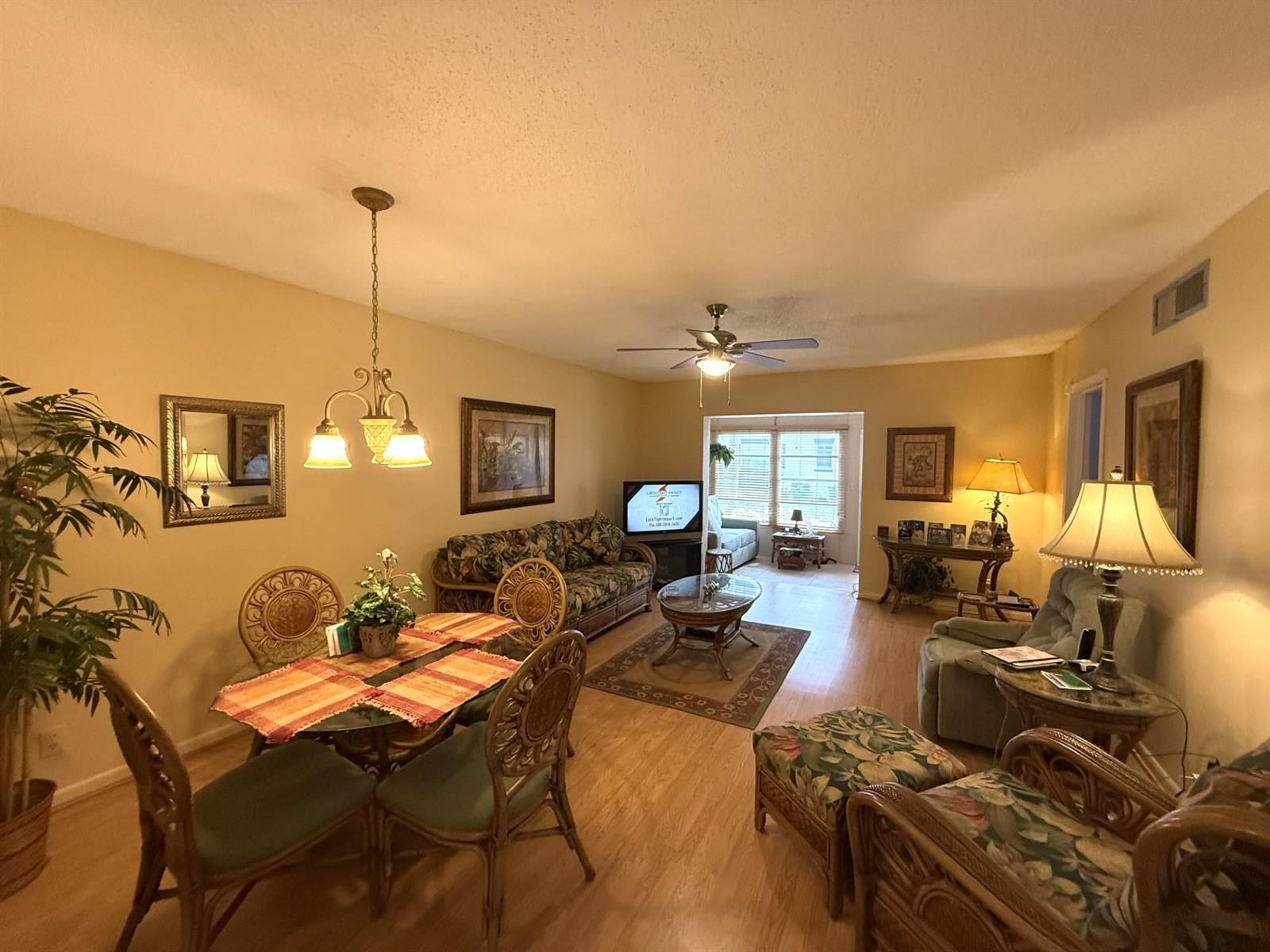 A living and dining room with rattan furniture, a ceiling fan, and light wood flooring — 375 SW 56th Avenue # 116, Margate FL 33068, MARGATE, FL