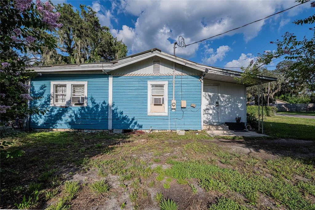 A single-story blue house with a white door and a window air conditioning unit — 2236 BURNS STREET, LAKELAND, FL