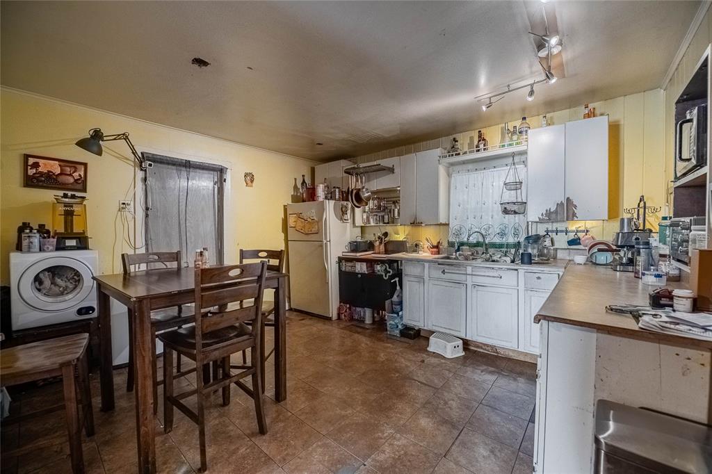 A kitchen with yellow walls, white cabinets, a dining table, and a washing machine — 2236 BURNS STREET, LAKELAND, FL