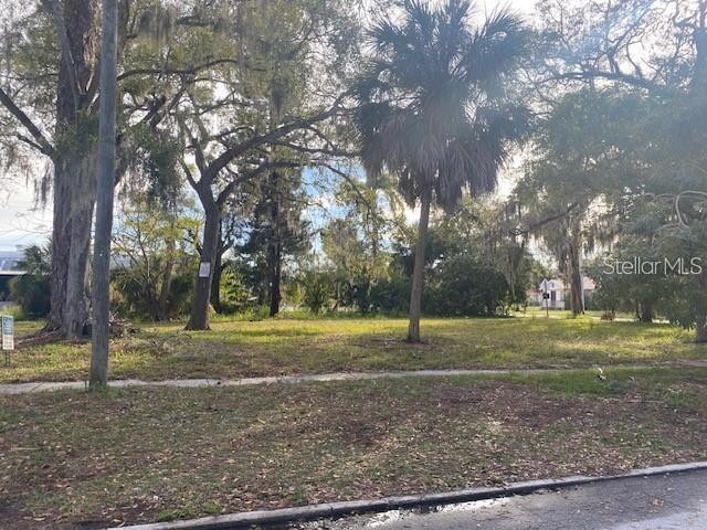 A vacant, grassy lot with mature trees and a palm tree under a bright sky — 1406 15TH STREET, SARASOTA, FL