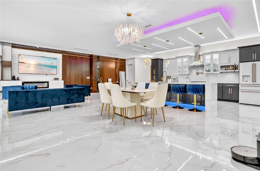An open-concept living and dining area features white marble floors, a crystal chandelier, and cabinetry — 18965 SHELDON STREET, ORLANDO, FL