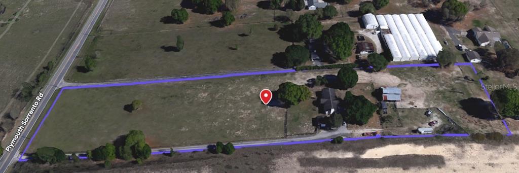 An aerial view shows a rectangular plot of land outlined in blue with several structures — 5221 PLYMOUTH SORRENTO ROAD, APOPKA, FL