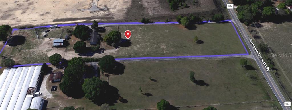 An aerial view shows a rectangular plot of land bordered by a road and trees — 5221 PLYMOUTH SORRENTO ROAD, APOPKA, FL