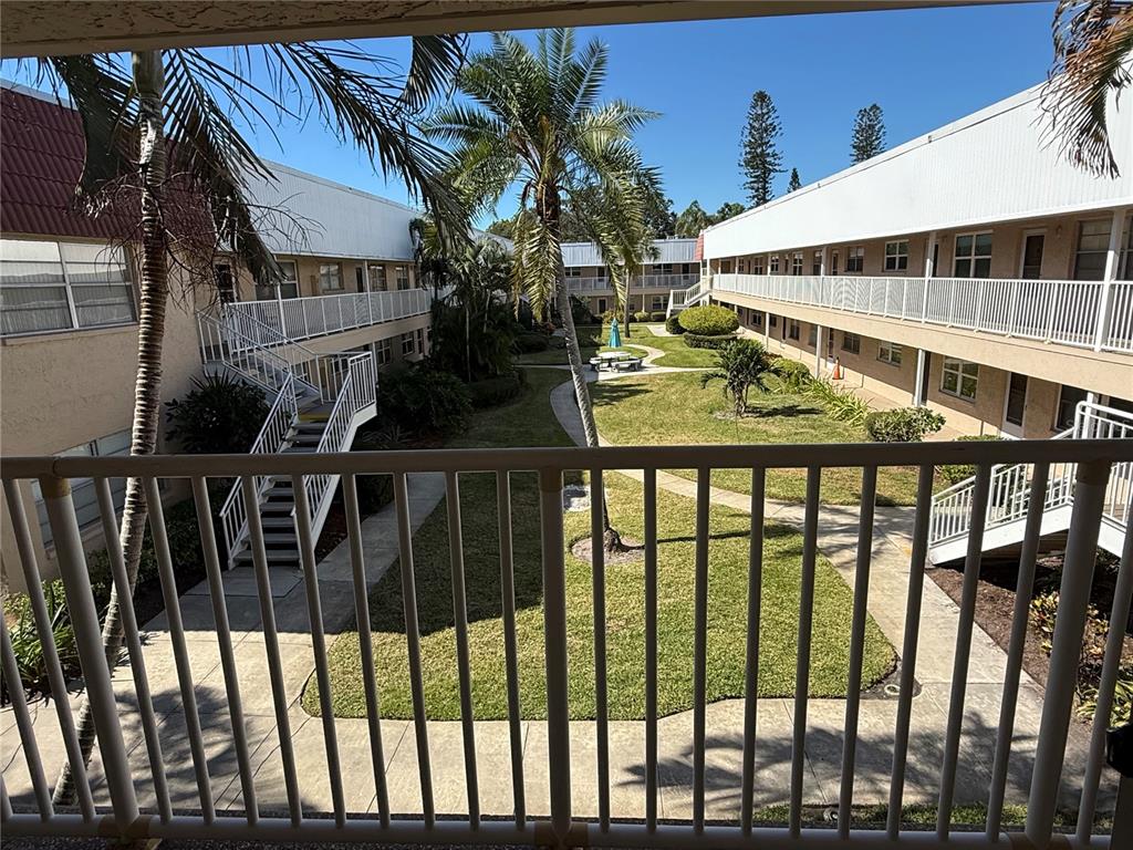 A view from a balcony overlooking a grassy courtyard between two apartment buildings — 10038 62ND TERRACE N UNIT 23, SEMINOLE, FL