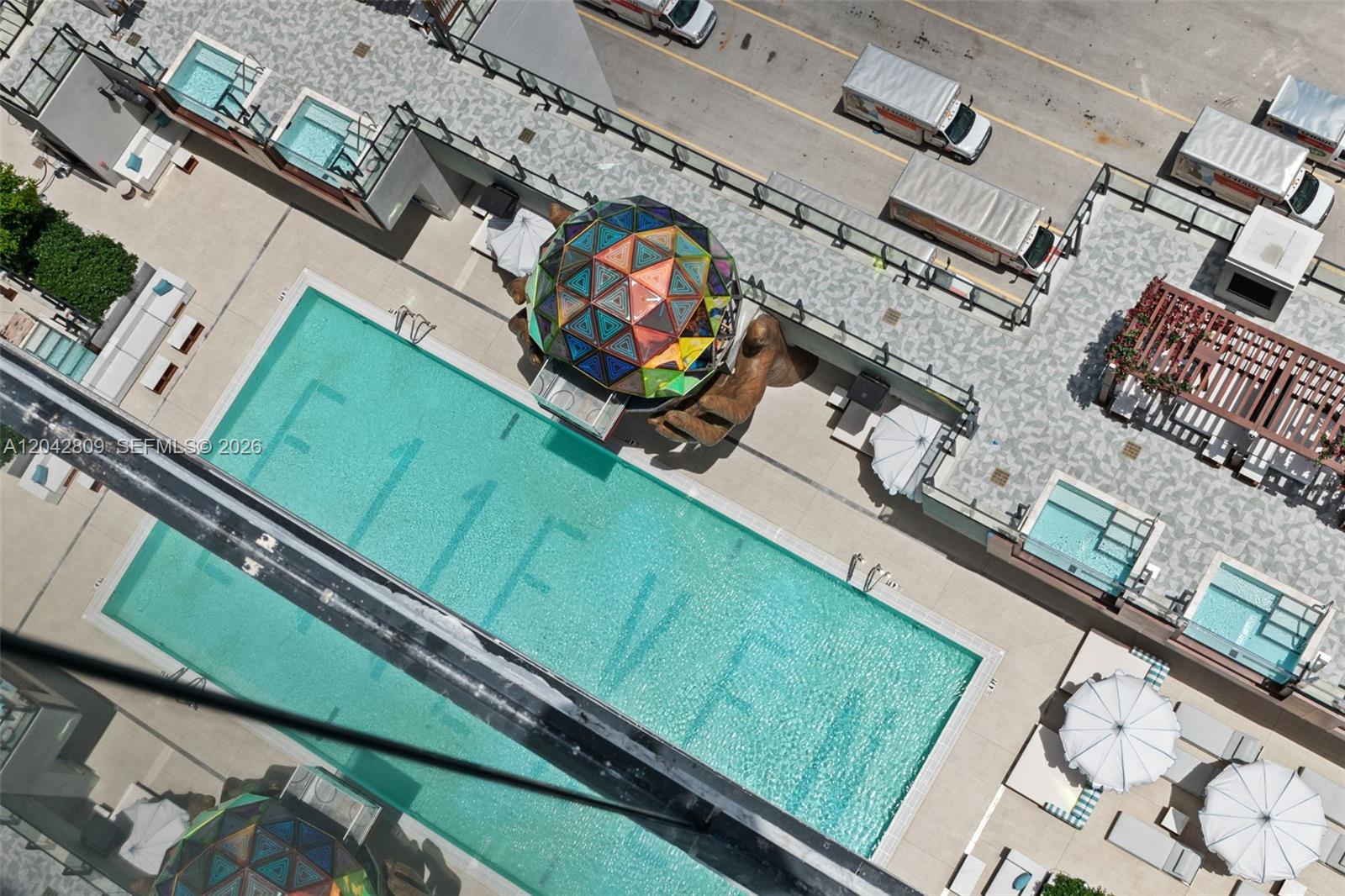 An aerial view shows a swimming pool with lettering, a geometric dome, and lounge chairs — 20 NE 11 # 2410, Miami FL 33132, MIAMI, FL