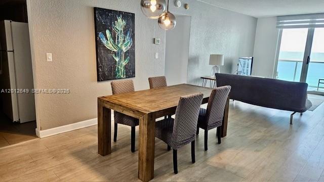 A dining area with a wooden table and chairs sits in front of a living room — 3901 S Ocean Dr # 11M, Hollywood FL 33019, HOLLYWOOD, FL