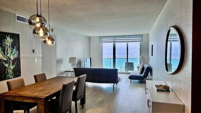 A dining area with a wooden table leads into a living room overlooking the ocean — 3901 S Ocean Dr # 11M, Hollywood FL 33019, HOLLYWOOD, FL
