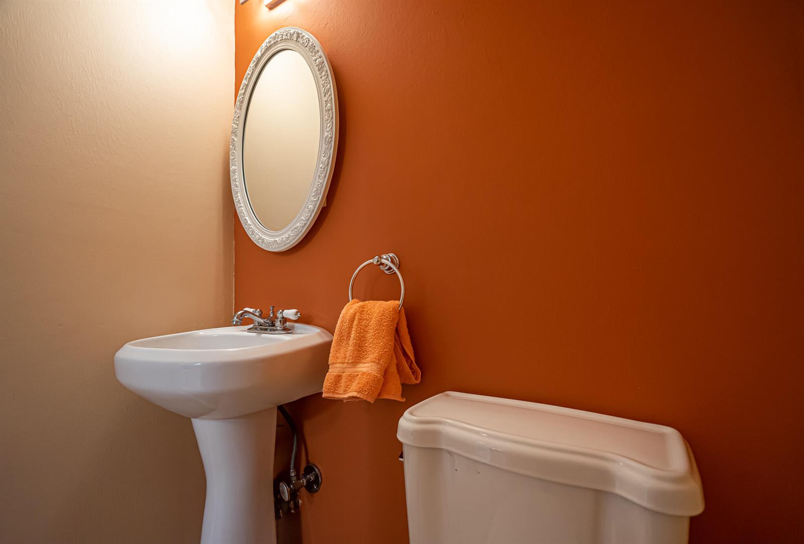 A bathroom features a pedestal sink, an oval mirror, and an orange towel on a ring — 1801 S Ocean Drive Unit 332, Hallandale Beach FL 33009, HALLANDALE BEACH, FL