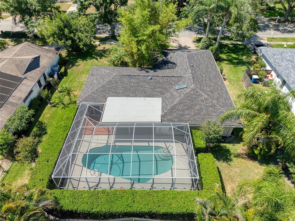 An aerial view shows a house with a screened-in swimming pool and a fenced backyard — 2972 KENILWICK DRIVE S, CLEARWATER, FL