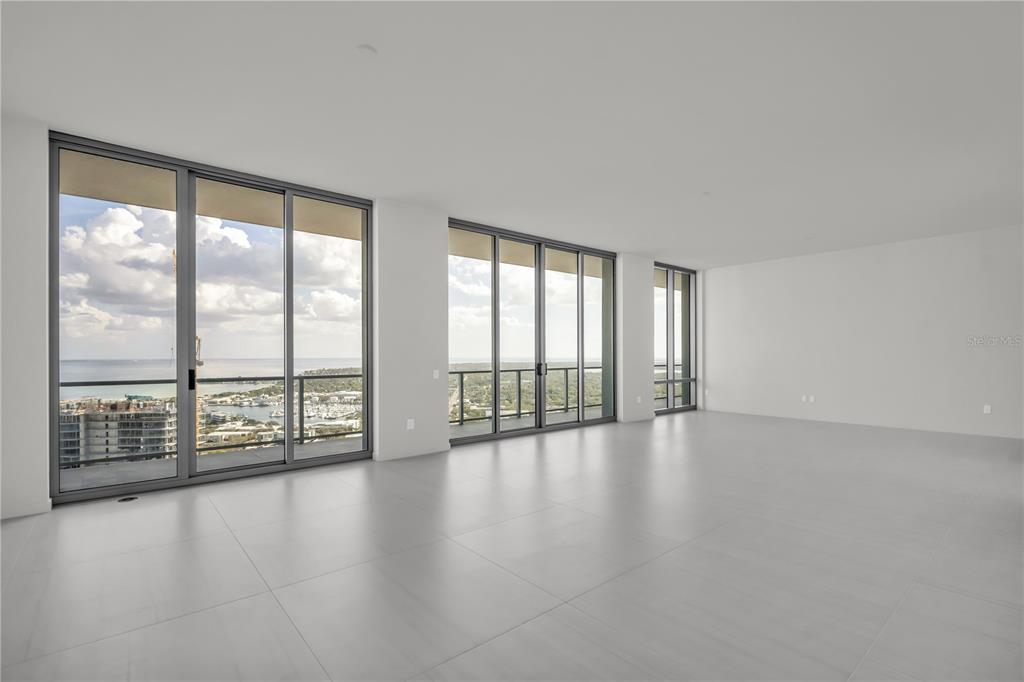 An empty, minimalist room features large floor-to-ceiling windows with views of the ocean — 400 CENTRAL AVENUE UNIT 4002, ST PETERSBURG, FL