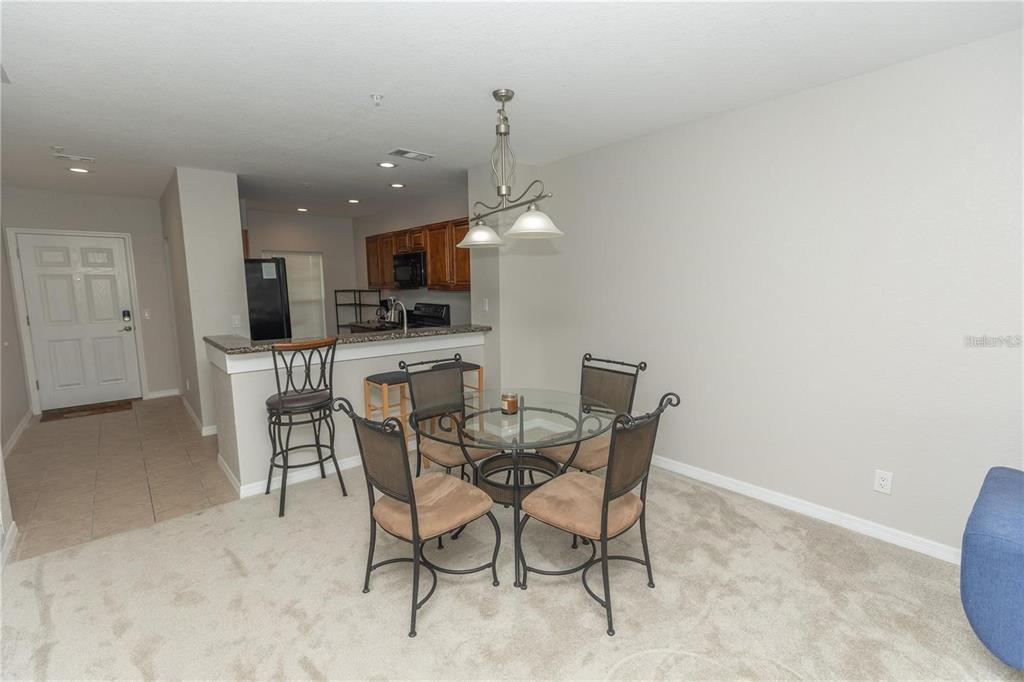 A dining area with a glass table and chairs sits adjacent to a kitchen counter — 8403 PLACIDA ROAD UNIT 303, PLACIDA, FL