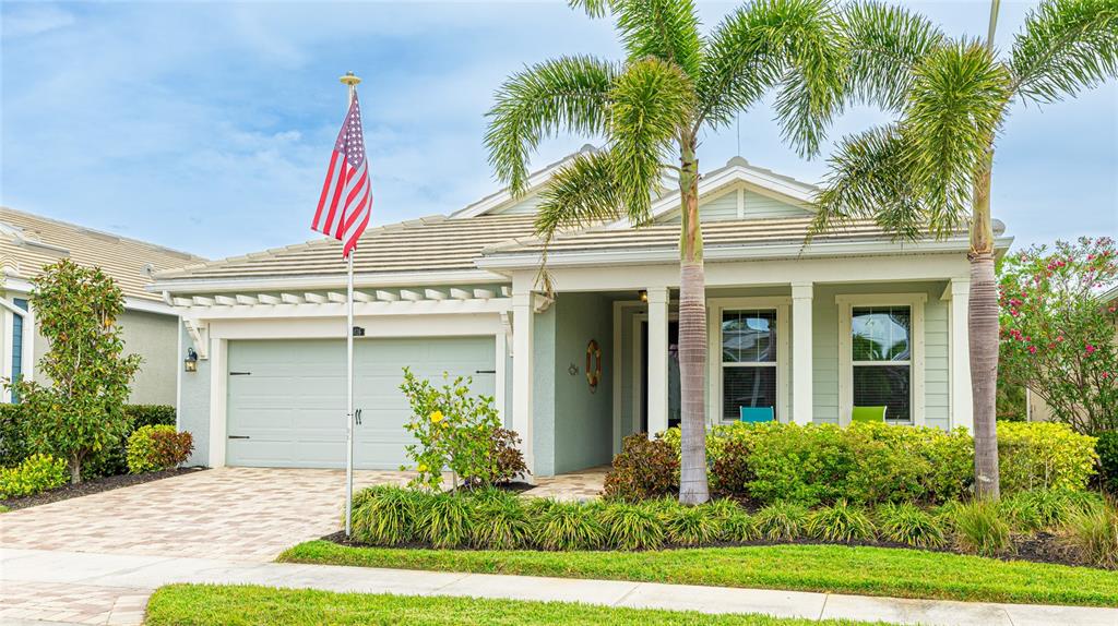 A light green house with a two-car garage, a front porch, and two palm trees — 5416 HOPE SOUND CIRCLE, SARASOTA, FL