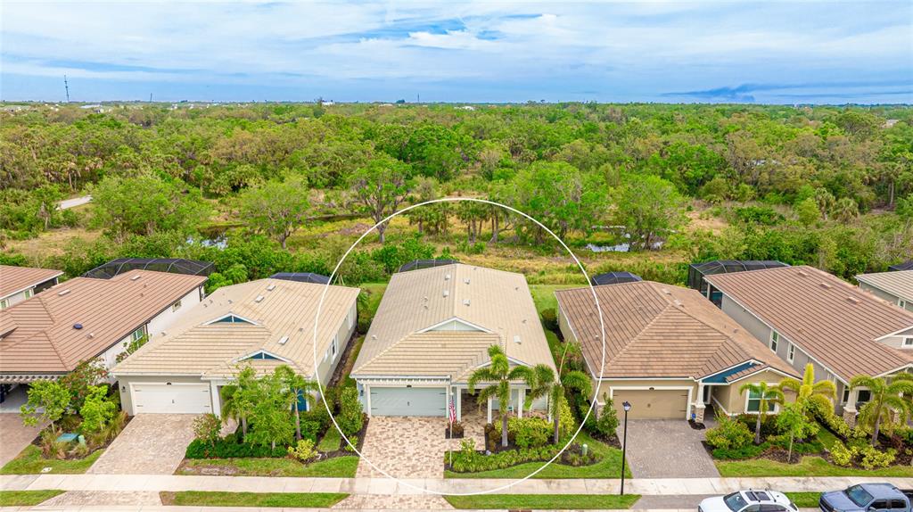 An aerial view shows a single-story house with a tiled roof and paved driveway — 5416 HOPE SOUND CIRCLE, SARASOTA, FL